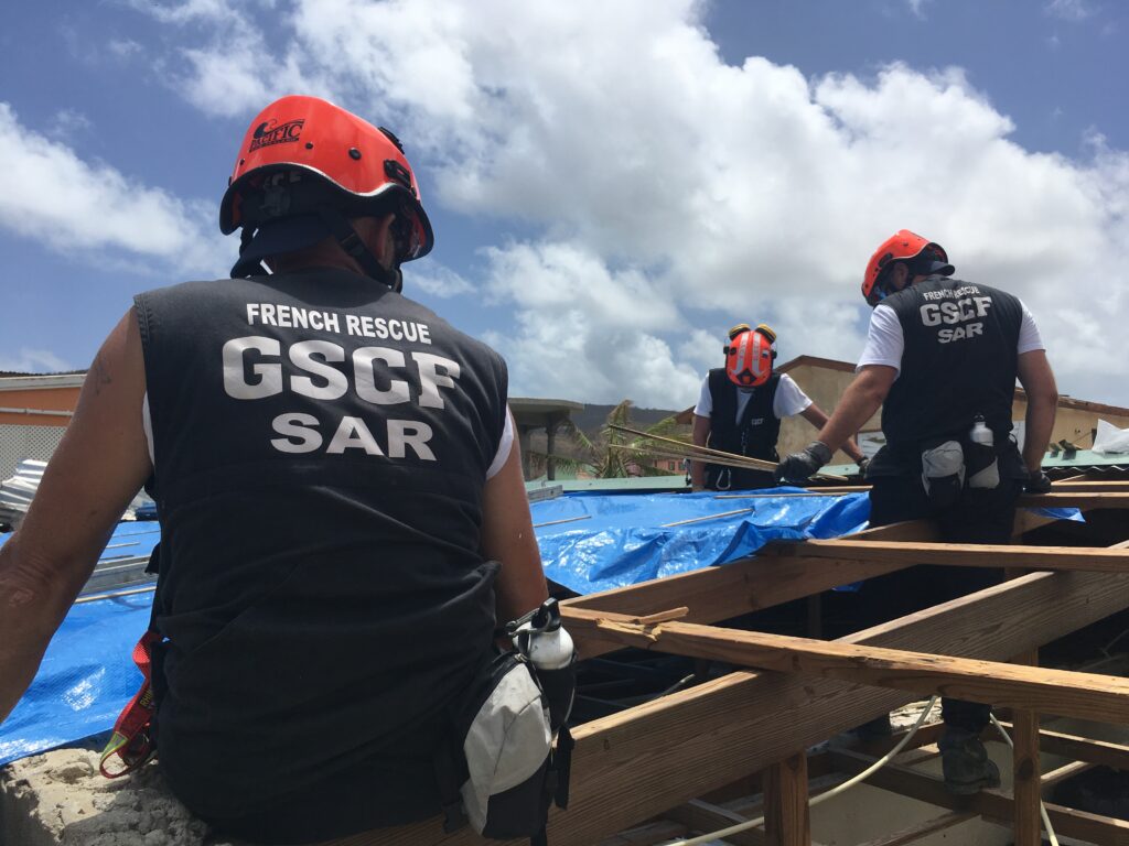 Équipe de pompiers du GSCF intervenant lors d'une mission de secours humanitaire en zone sinistrée, apportant aide et soutien aux victimes de catastrophes.